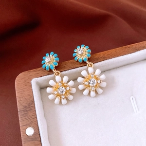 Détail des boucles d'oreilles marguerites avec émail bleu et cristaux brillants