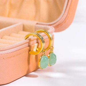 Detail of green aventurine earrings on a pink jewelry box with 18K gold plated finish
