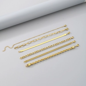 Detail of 6-piece bohemian gold chain bracelet set including snake and figaro styles