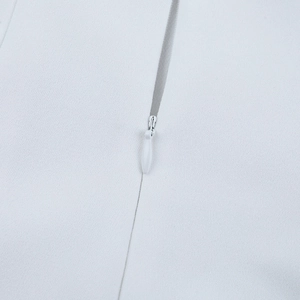 Detail of white dress showing high-quality invisible back zipper and fine fabric texture