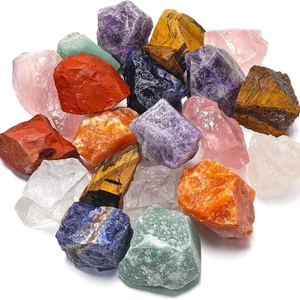 Set of natural raw crystal stones including amethyst, tiger eye and quartz on white