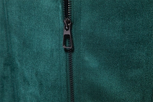 Macro detail of dark green suede jacket fabric with high-quality metal zipper