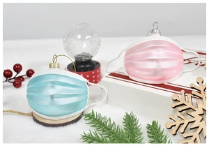 Dettaglio di decorazioni natalizie a forma di mascherina rosa e blu con bordi glitterati