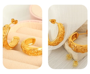 Close-up of golden C-shaped celestial earrings with star and moon patterns and zircons