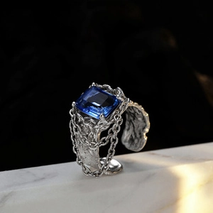 Detail of S925 sterling silver multilayer ring with blue gemstone on marble surface