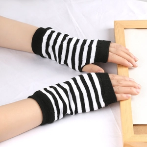 Gants en tricot à rayures noires et blanches sans doigts sur la main d'un modèle