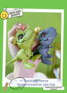 Close-up of green and grey dinosaur keychains with golden bells and biting feature