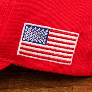 High-quality close-up of American flag embroidery on a classic red cotton baseball cap
