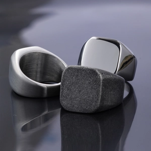 Detail of square signet rings showing brushed, mirror, and sandblasted metal finishes