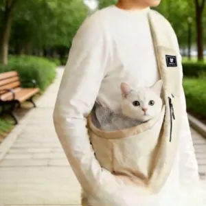 Detail view of a beige canvas pet sling carrier with breathable grey mesh and wide strap