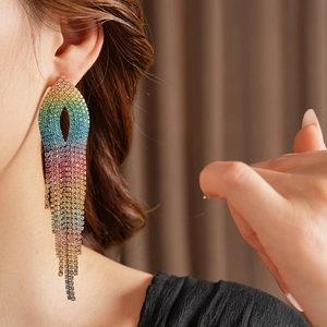 Macro shot of long rainbow gradient tassel earrings with rhinestones on a model