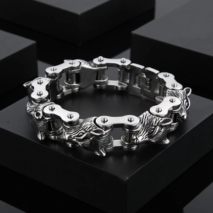 Detail der Wolfskopf-Schnitzerei und der schweren Motorradkettentextur auf dem Armband