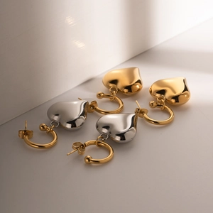 Macro shot of gold and silver heart earrings with polished finish and secure clasp details