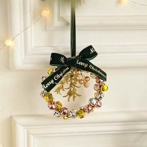 Christmas wreath with gold silver and pink bells and a dark green velvet bow decoration