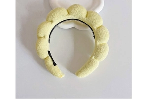 Detailed top view of a yellow plush cloud headband with black non-slip inner teeth
