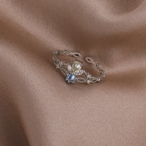 Close-up of vintage crown ring with blue and yellow gems on brown satin fabric