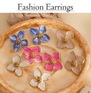 Collection de boucles d'oreilles fleurs en émail coloré sur un plateau texturé
