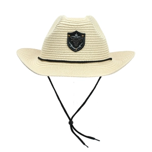 Detail of light beige straw cowboy hat with silver bull head emblem and adjustable drawstring