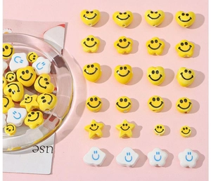 Mix of yellow and white ceramic smiley face beads in round, heart, and flower shapes
