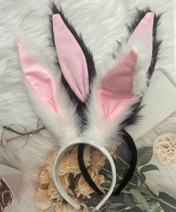Close-up of black and white plush rabbit ear headbands with soft pink inner linings