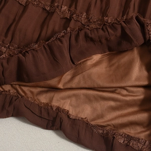 Detail of dark brown layered lace fabric with pleated design and silk-like inner lining