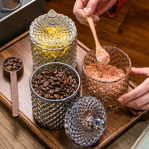 Macro detail of diamond-textured glass storage jars with lids on a wooden tray