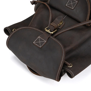 Macro view of vintage brown crazy horse leather backpack with rustic metal buckle and stitching