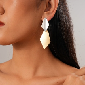 Interlocked gold and silver geometric rhombus earrings worn on model for modern style