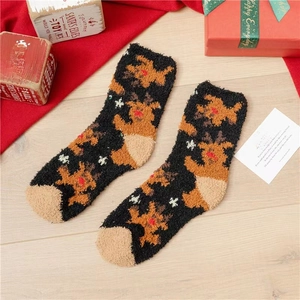 Detail of soft coral fleece Christmas socks featuring reindeer motifs and snow patterns