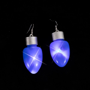 Dettaglio macro di orecchini a forma di lampadina di Natale blu luminosi su sfondo nero