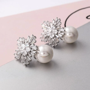 Macro detail of elegant snowflake pearl earrings with silver finish and micro-inlaid stones