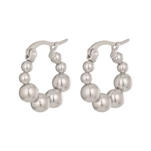 Détail des boucles d'oreilles huggie en acier argenté avec perles polies en dégradé