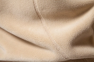 Close-up of soft beige polar fleece fabric with premium stitching details for warmth