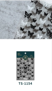 Macro shot of 5D white and black butterfly embossed nail stickers with fine relief details