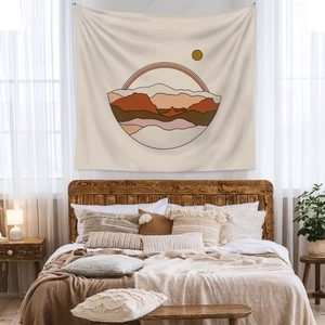 Detail of bohemian tapestry featuring warm sun and mountain graphics in cozy bedroom
