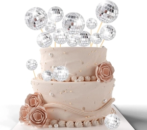 Silver disco mirror ball cake toppers in various sizes on a pink layered cake