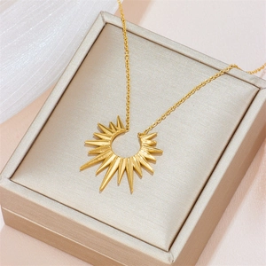 Golden stainless steel sunburst pendant necklace elegantly displayed in a beige jewelry box