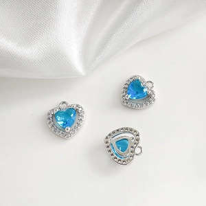 Vue détaillée de breloques en forme de cœur avec zircons bleu ciel et placage argenté