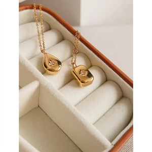 Gold plated square and waterdrop pendant necklaces with starburst zircon in jewelry box