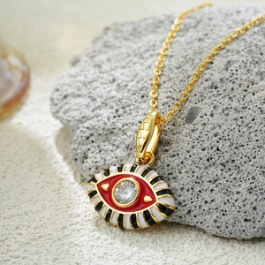 Macro view of 18K gold evil eye pendant with colorful enamel and sparkling zircon detail