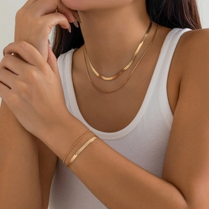 Close-up of a double-layered gold snake bone chain necklace and matching bracelet set