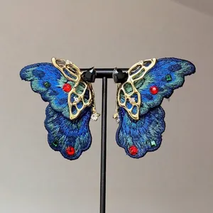 Boucles d'oreilles papillon vintage avec broderie bleue et cristaux sur support noir