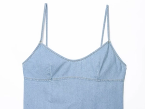 Nahaufnahme der hellblauen Denim-Textur und Nähte auf dem Oberteil mit Spaghettiträgern