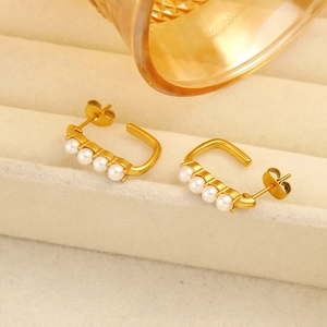 Detail of 18K gold plated C-shaped earrings featuring four white pearls and butterfly back