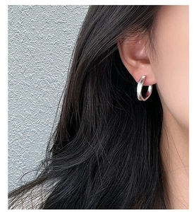 Close-up of minimalist S925 sterling silver C-shaped hoop earring on model ear