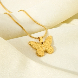 Elegante collana con pendente a farfalla placcata oro 18K su sfondo di seta lucida
