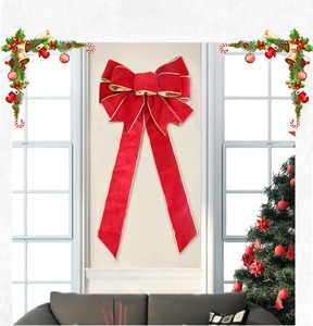 Close-up of a 60cm red velvet Christmas bow with gold trim on a festive window display