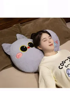 Detailed close-up of a soft grey plush cat pillow with yellow eyes and pink nose