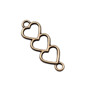 Macro detail of triple heart link connectors in vintage bronze alloy for DIY jewelry