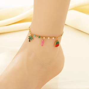 Détail d'une chevillère dorée à double couche avec pendentifs palmier, piment et fraise